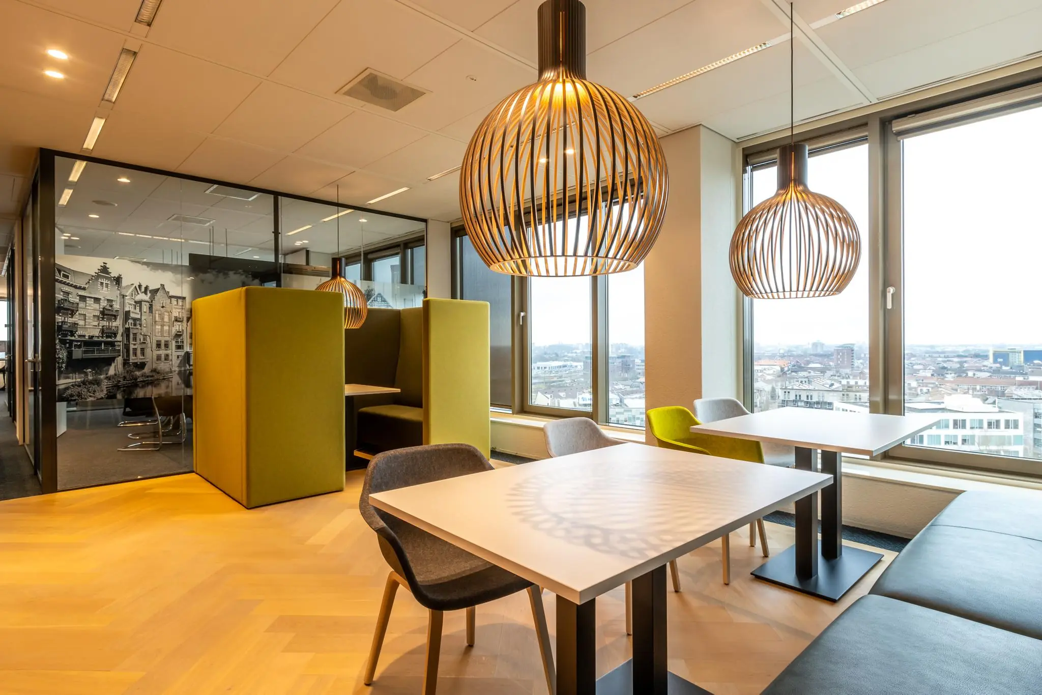 Moderne kantoorlounge aan de Fascinatio Boulevard met zitjes, designlampen en uitzicht over de stad.